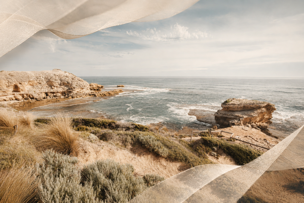 A scenic coastal landscape with rocky cliffs, ocean waves, and a pale sky, overlaid with a translucent draped fabric texture at the top and bottom edges.