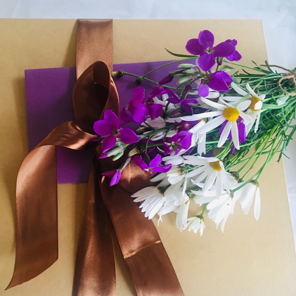 Complimentary Fresh flowers and card on gift box.